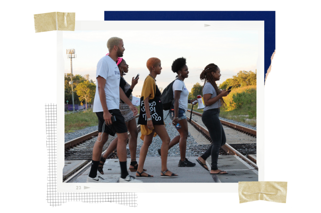 Five people crossing railroad tracks.